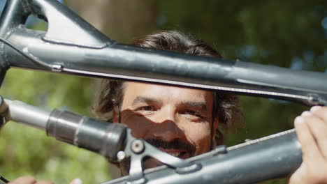 Close-up-shot-of-happy-man-looking-at-camera-throw-bicycle
